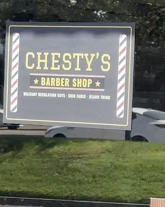 The Chesty's Barber Shop decal on the glass of the front door